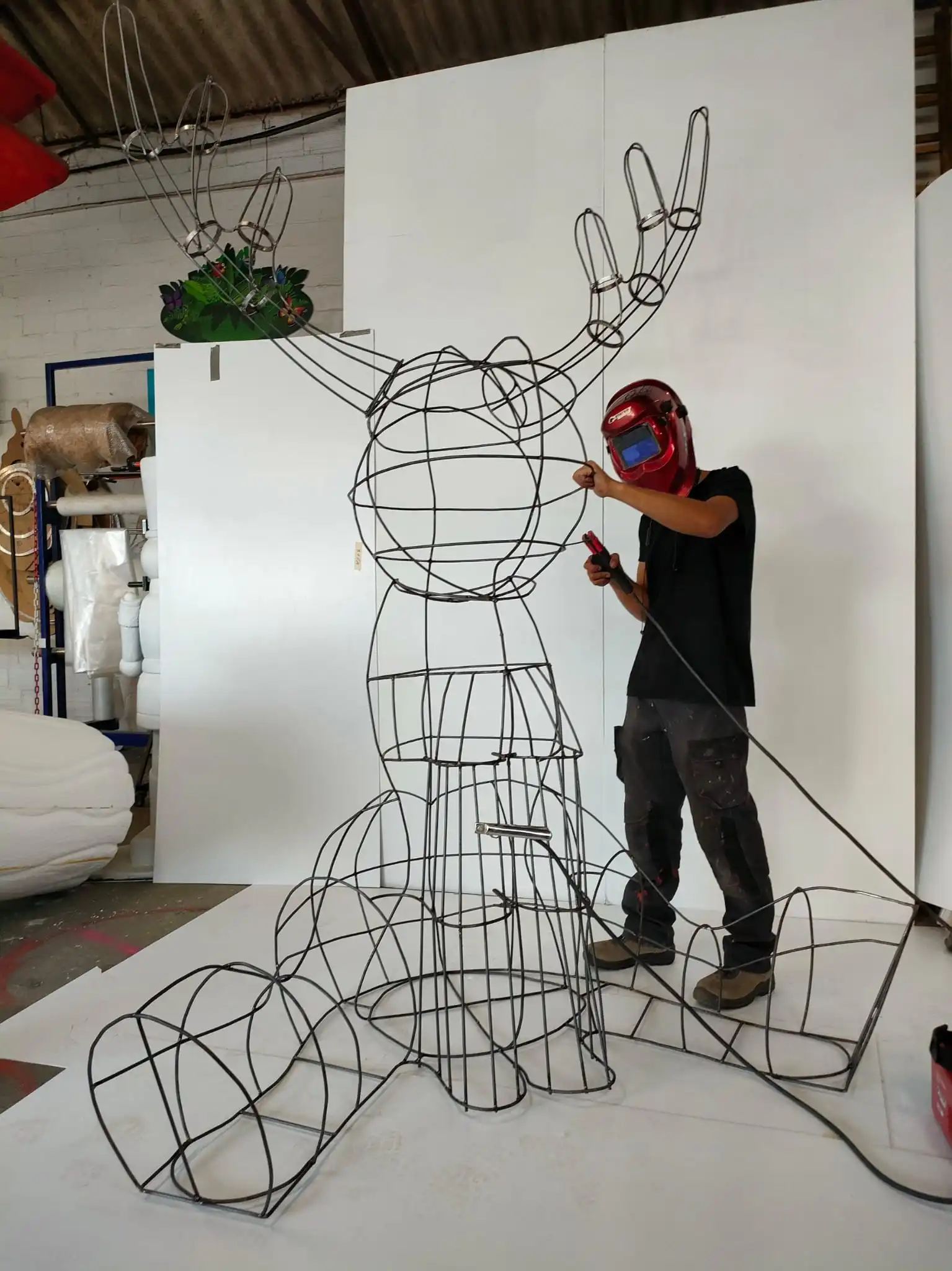 Escultura de renos en malla tejida de alambre, elaborada artesanalmente con técnicas de corte, soldadura y herrería, decorada con ramas de abeto para una exhibición navideña en un hotel de Madrid